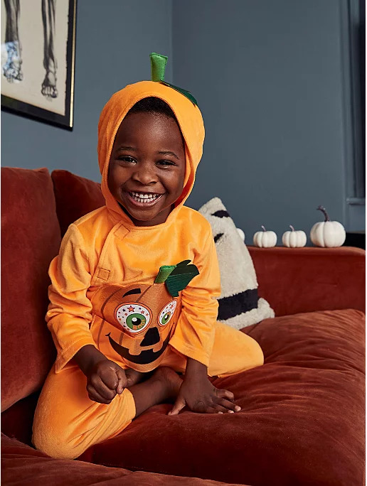 Little boy dressed in a Halloween pumpkin onesie